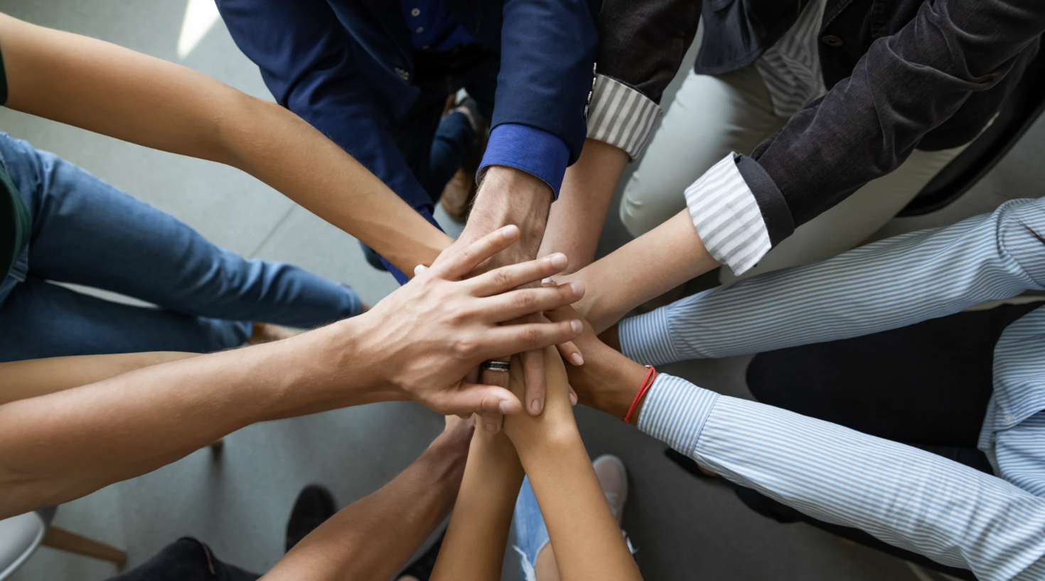 People putting their hands together in a circle.