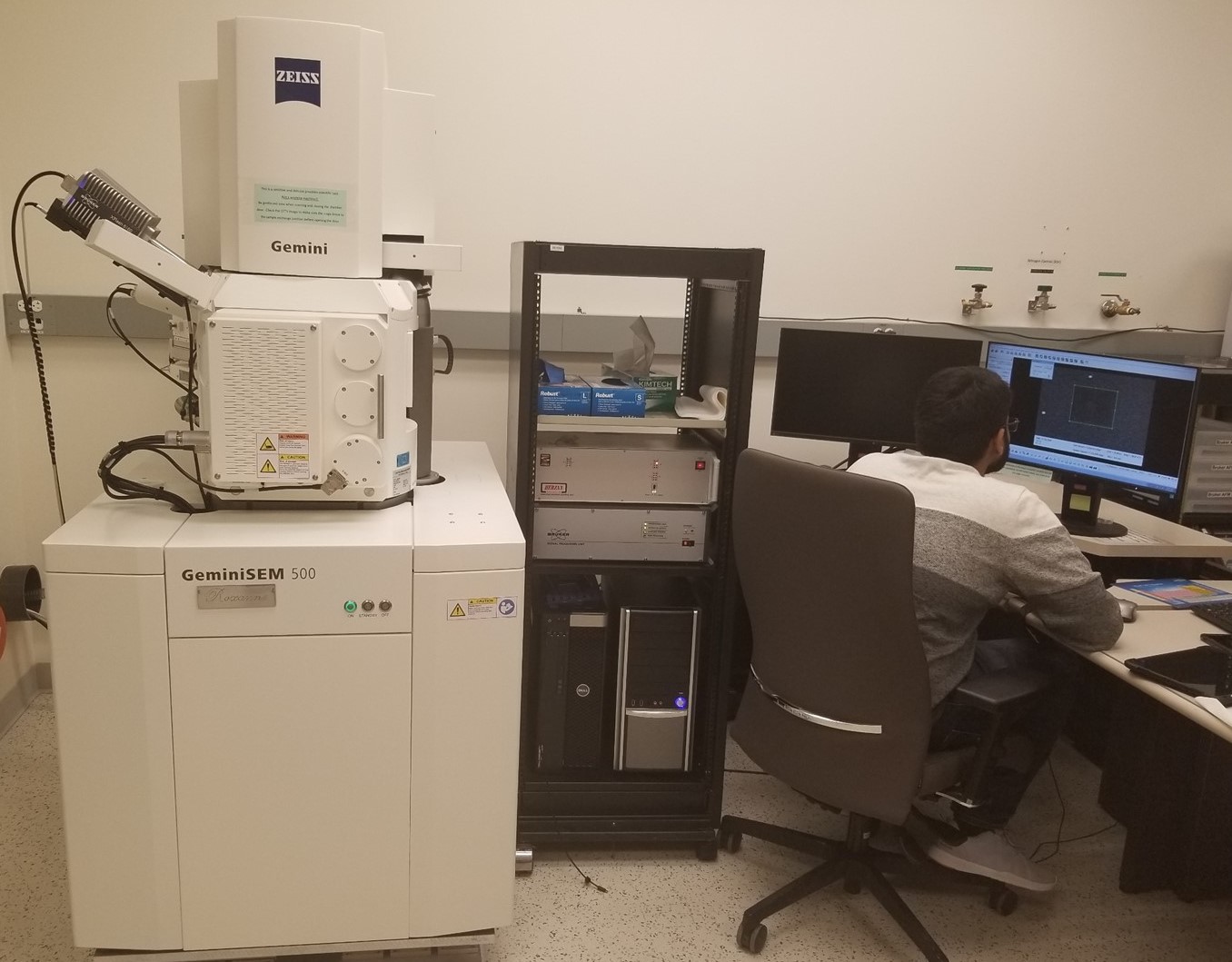 Student working at a computer next to the GeminiSEM 500