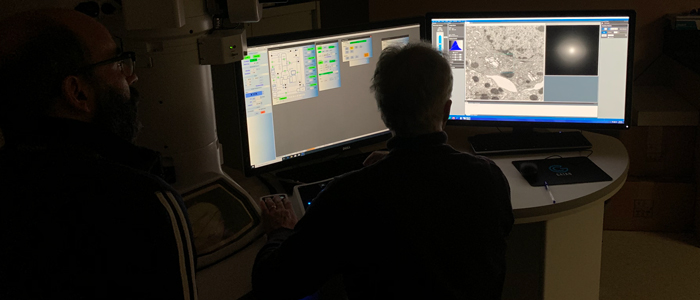 Person in lab looking at two computer screens