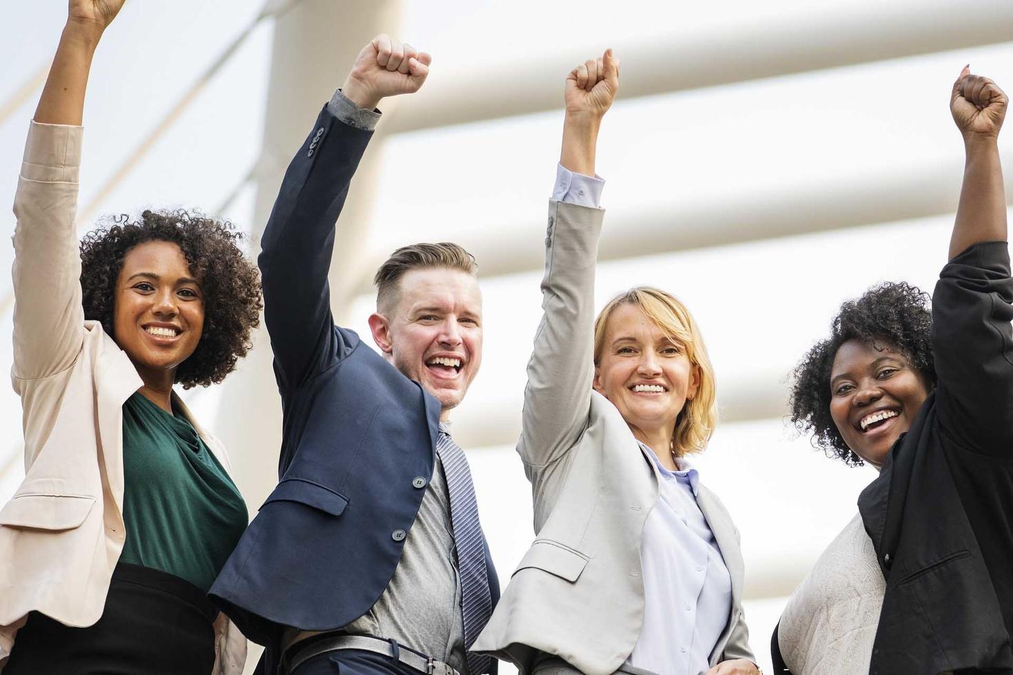 Four people raising one hand to the sky