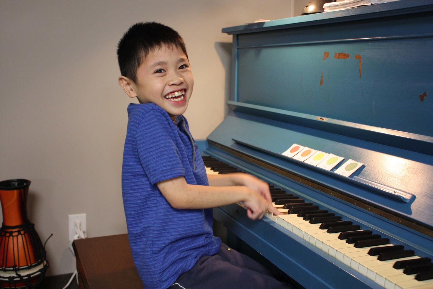 A young boy playing piano