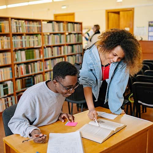 Two young adults reading a book