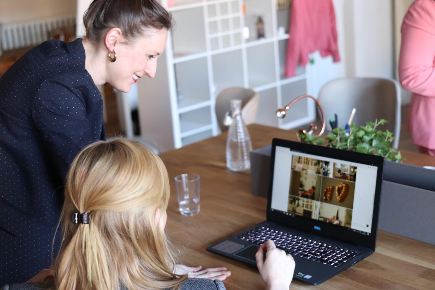 Coworkers looking at a laptop screen during a virtual meeting