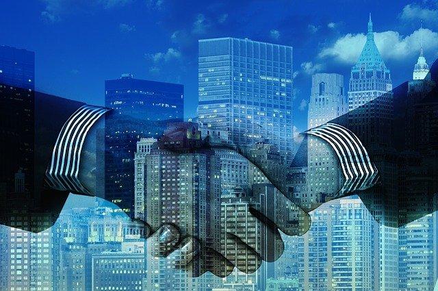 A handshake with a background of buildings