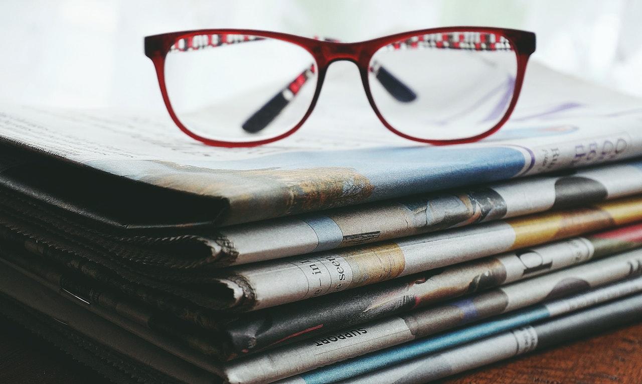 glasses on s stack of newspaper
