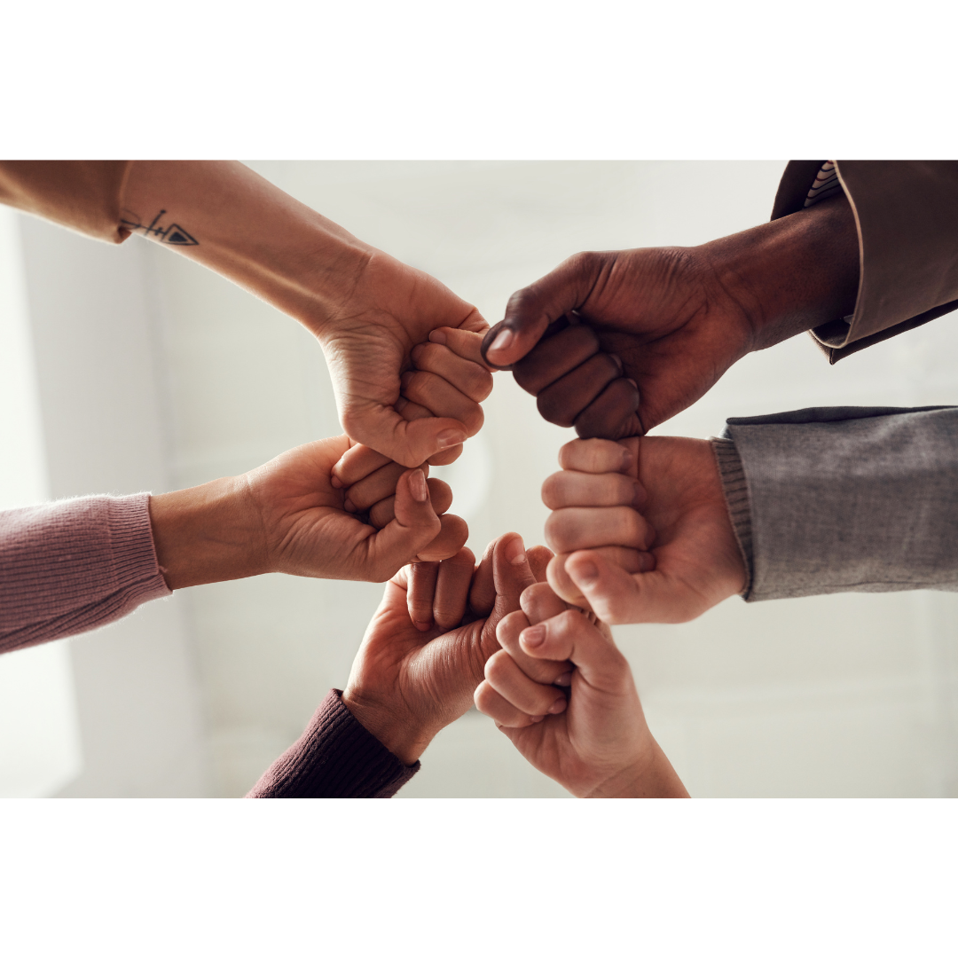 Diverse group of people fist bumping in a circle