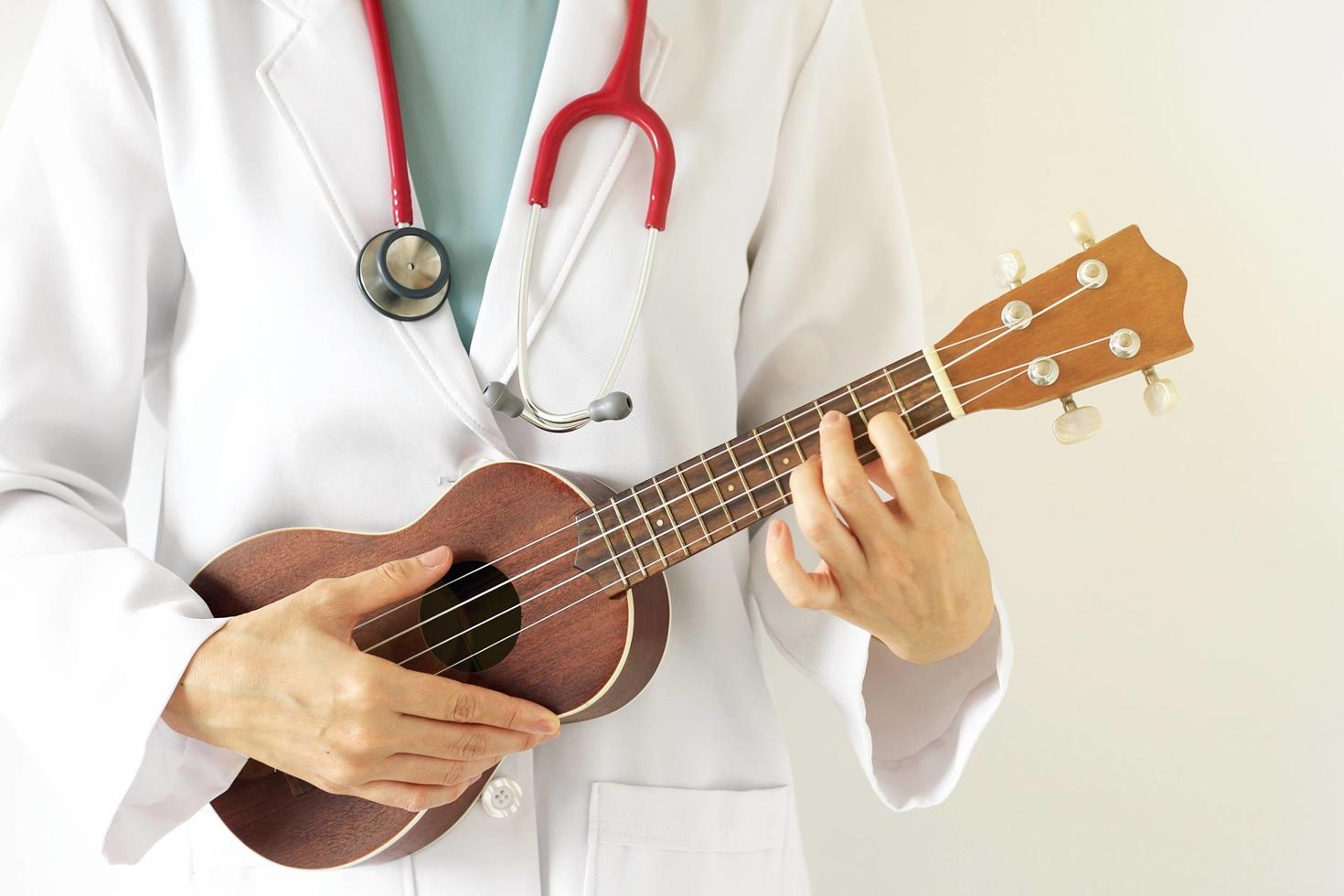 Person in medical garb holding a ukulele