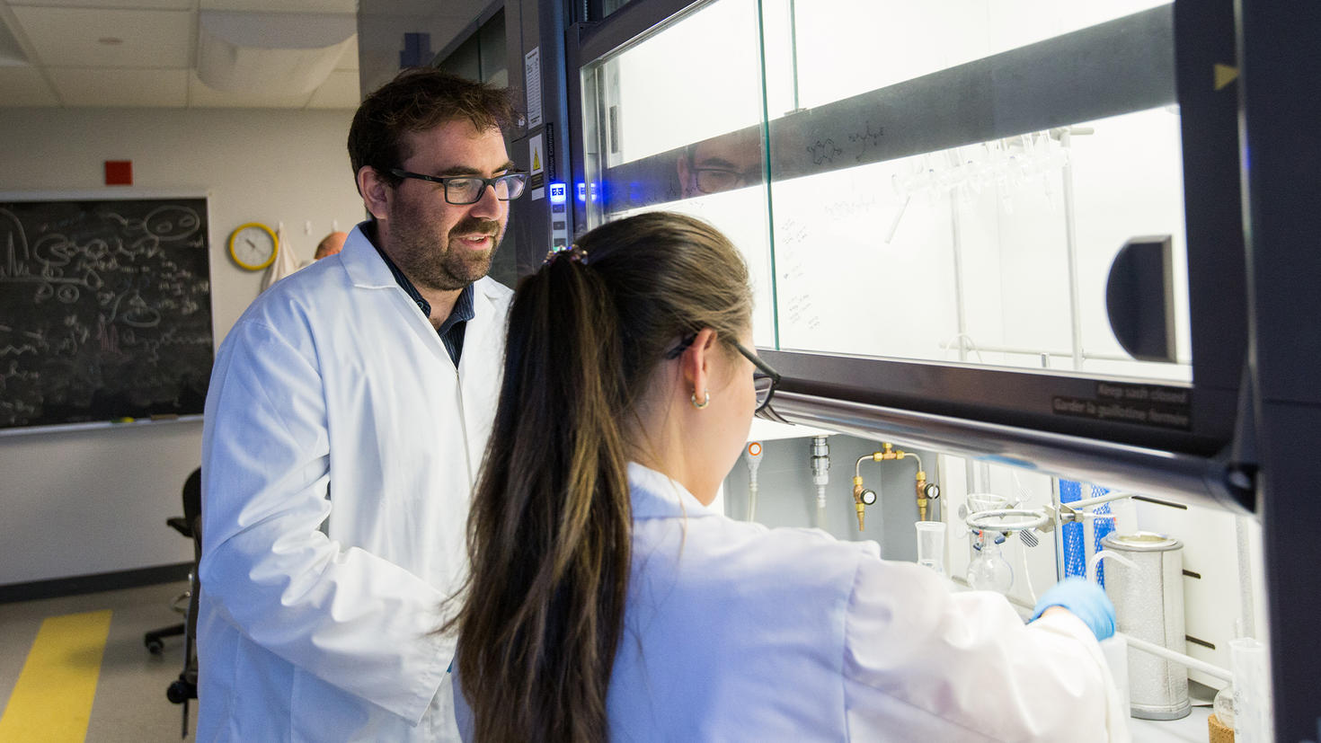 Researcher Adam Shuhendler in his lab working with a student