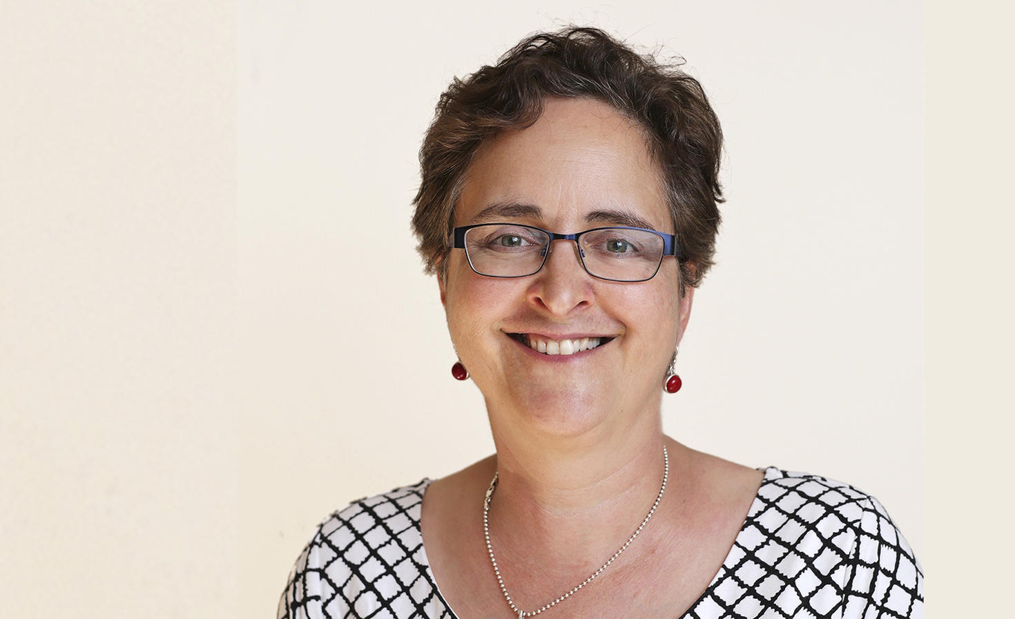 Professor Teresa Scassa in front of a beige backdrop