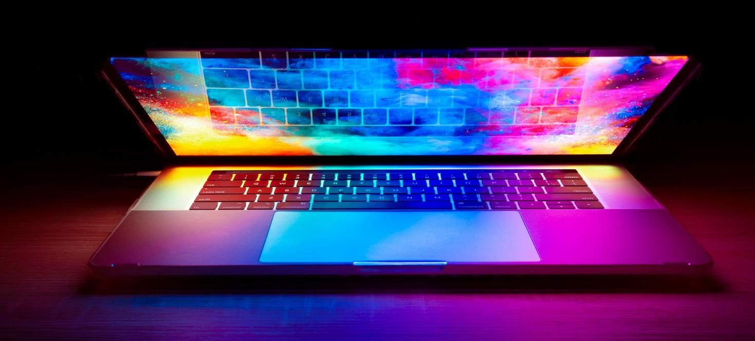 Partially open laptop glowing with colorful light