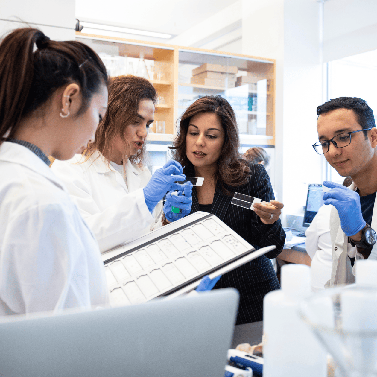 Nafissa Ismail and students looking at samples.