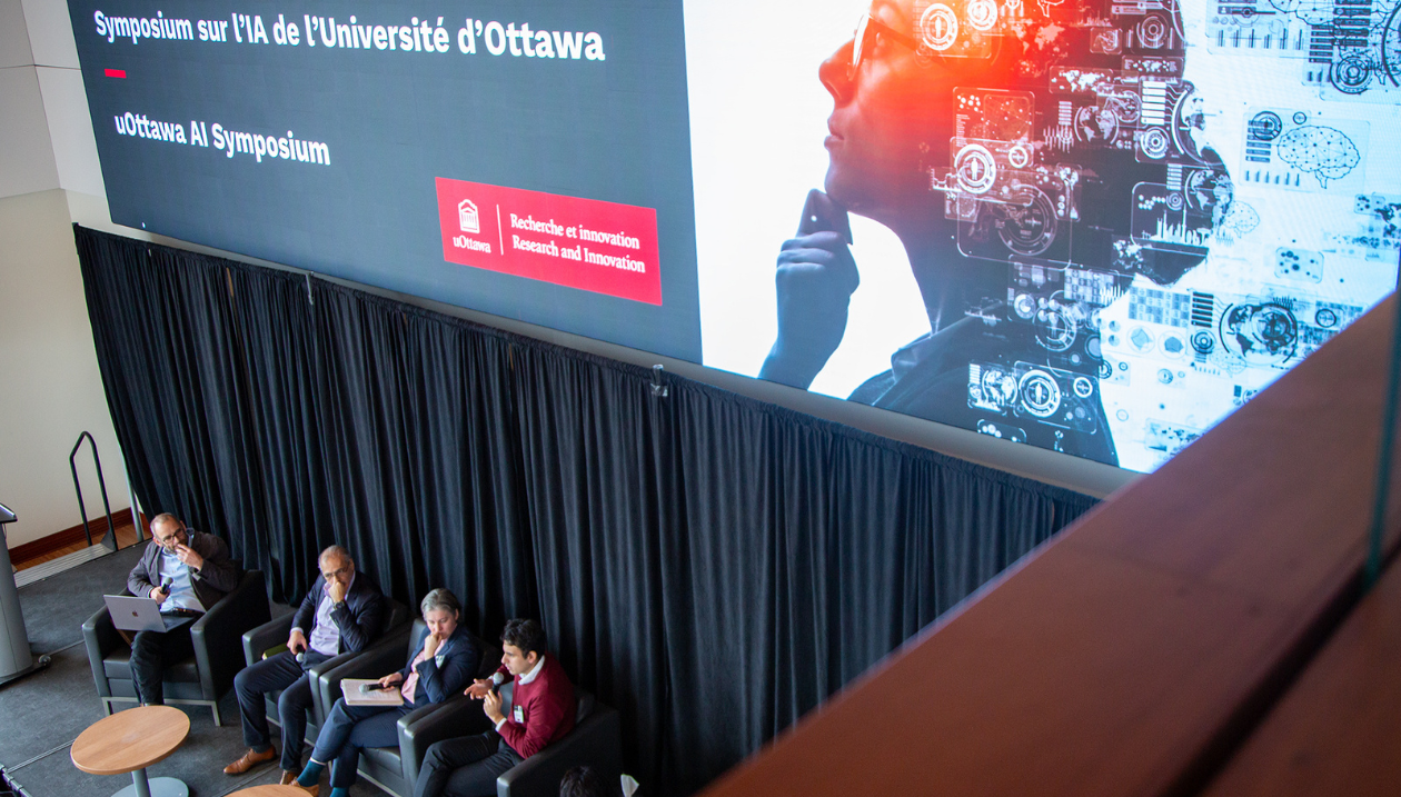 Panelists on stage at the uOttawa AI Symposium seen from above. 