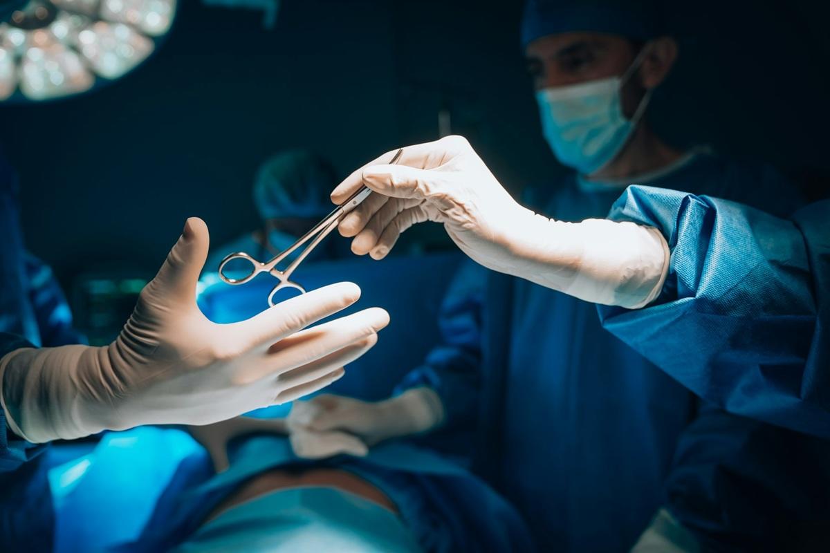 Surgeons work together on patient in operating room.