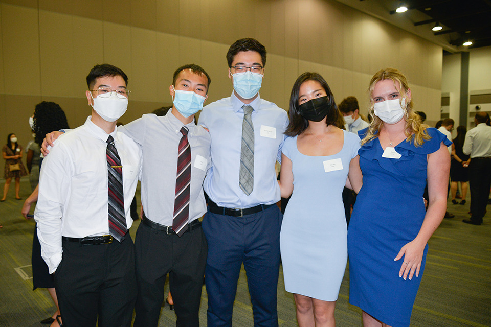 Five medical learners pose wearing face masks.