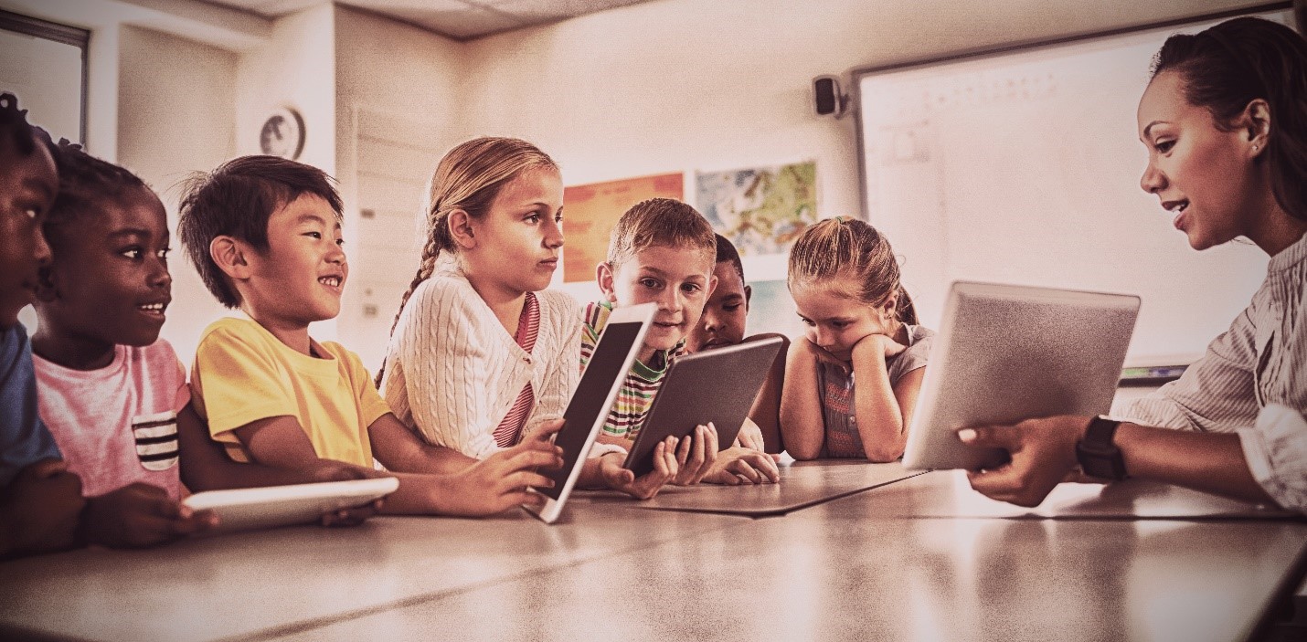 Une enseignante tient une tablette électronique devant des élèves