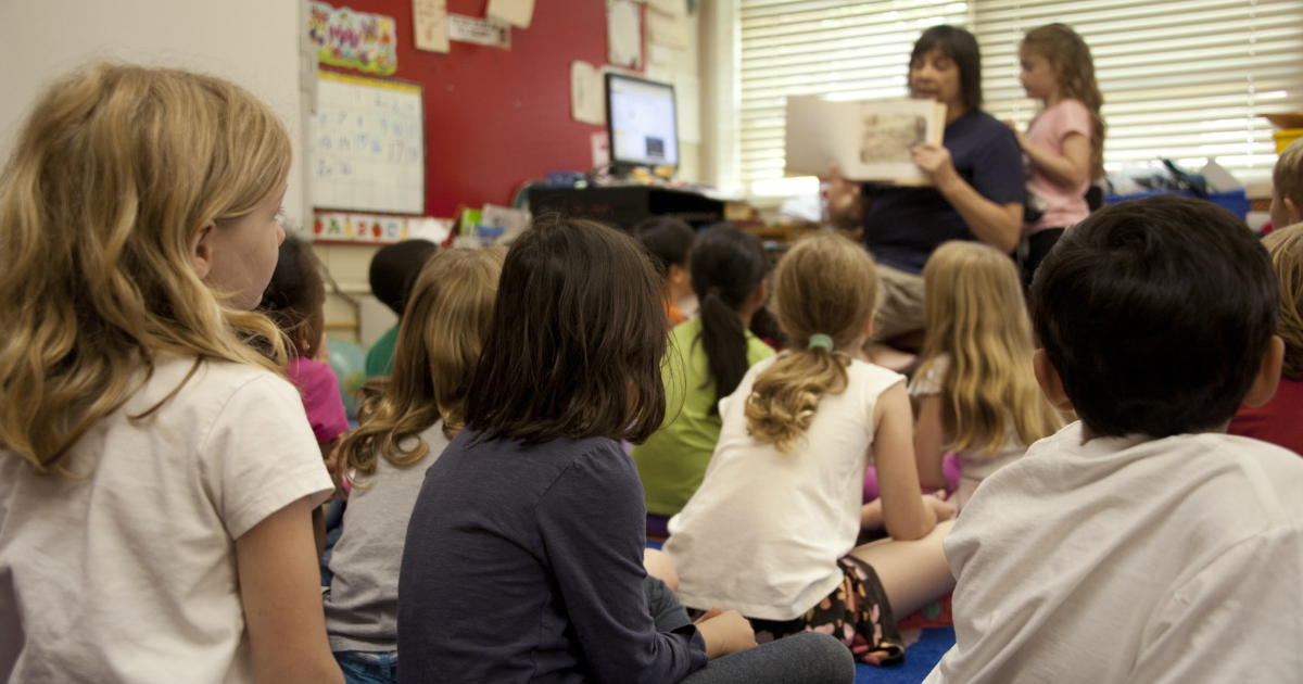 Une enseignante lit un livre à des enfants dans une classe