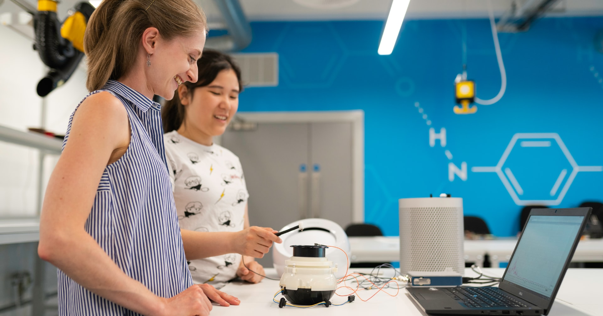 Two people in a classroom with technology equipment