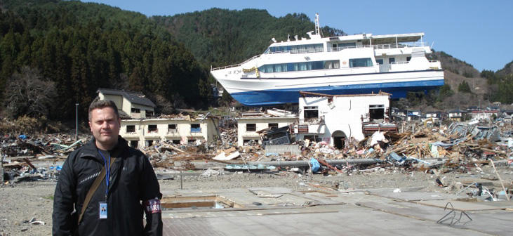 Le professeur Ioan Nistor se tient près d'un navire détruit par un tsunami au Japon. 