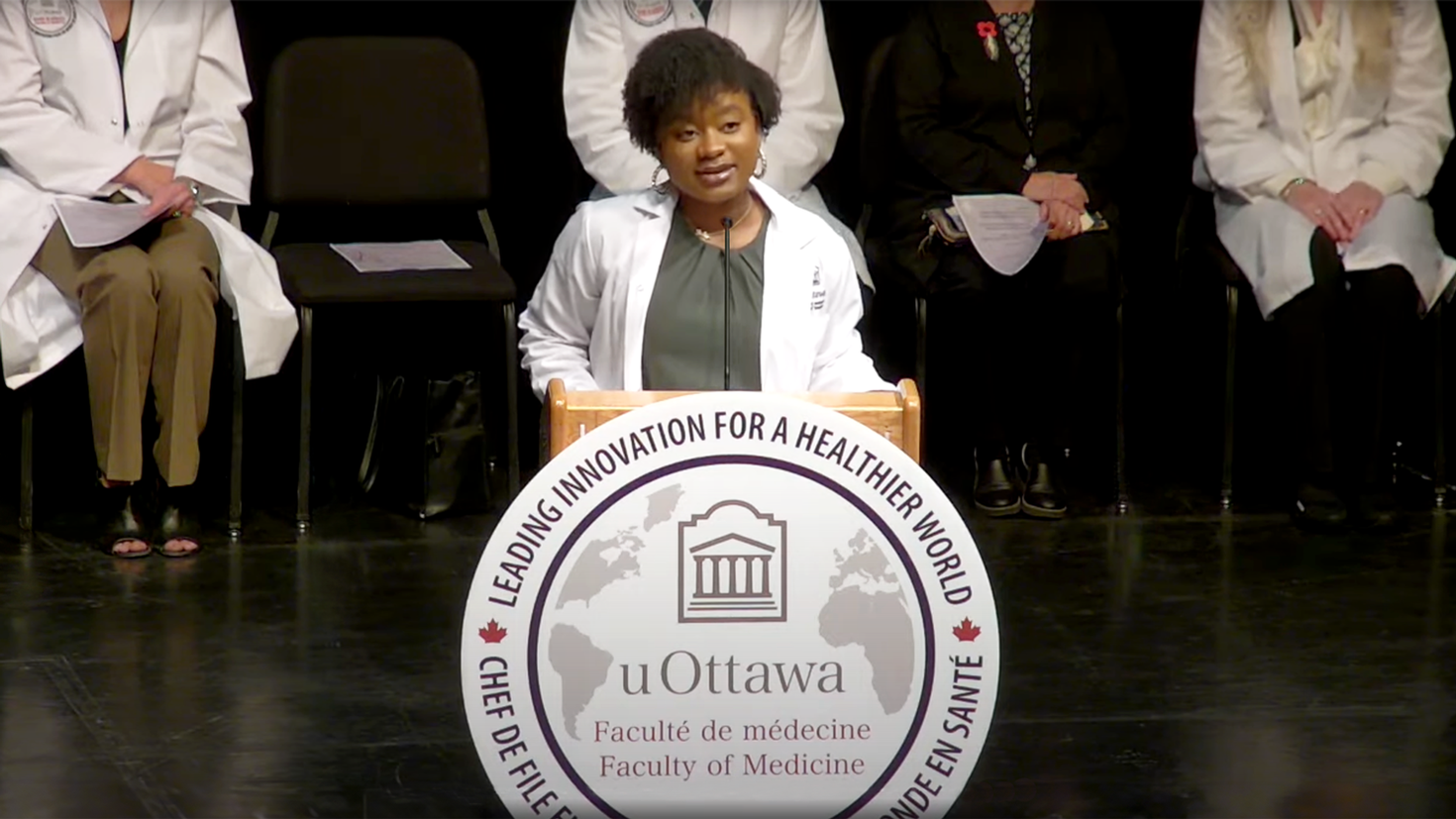 Julia Kemzang parlant à un pupitre.