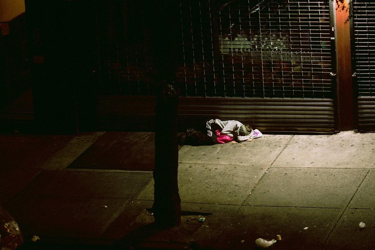 Homeless person sleeping on sidewalk