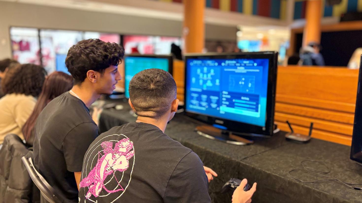 Deux étudiants jouant à un jeu vidéo.