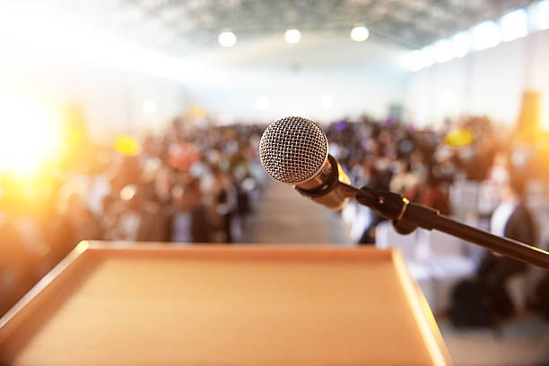 Microphone devant une foule assise et floue