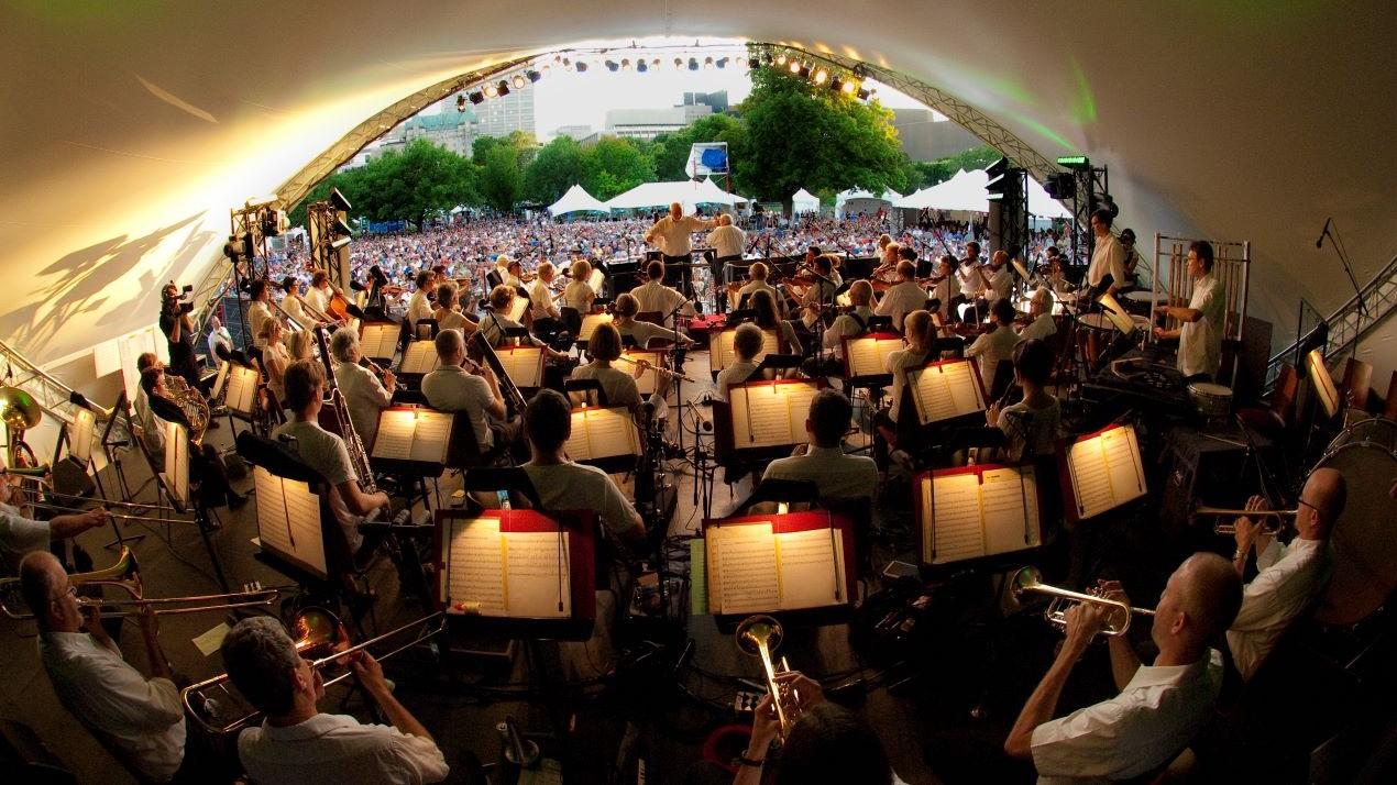 Vue des coulisses d'un orchestre de jazz se produisant devant un public.