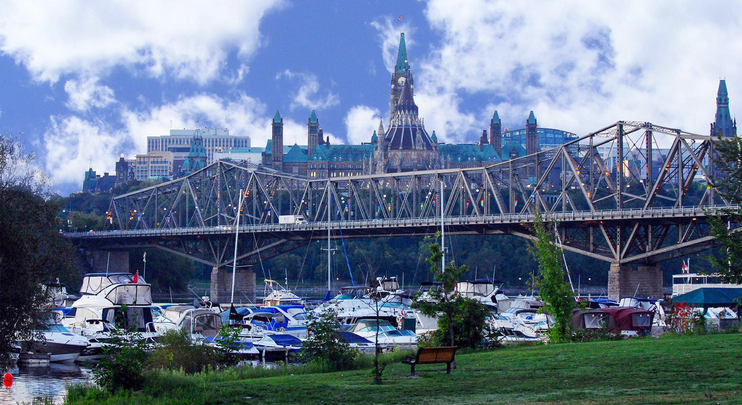 The Houses of Parliament with the Alexandra Bridge and boats in the foreground.