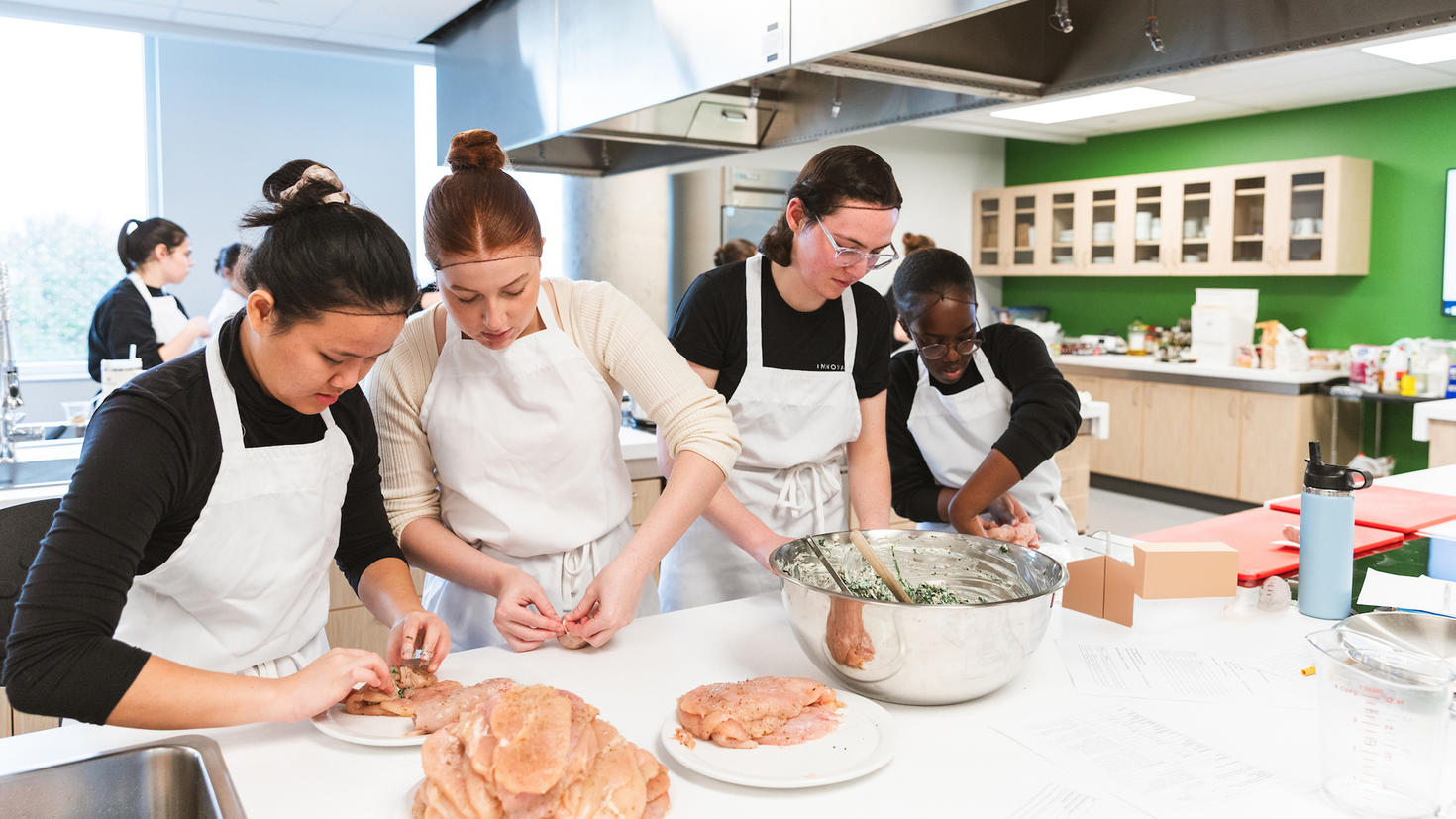 Les étudiants du programme de nutrition de la Faculté des sciences de la santé préparent des aliments dans les laboratoires de nutrition pour un événement célébrant l'ouverture des laboratoires.