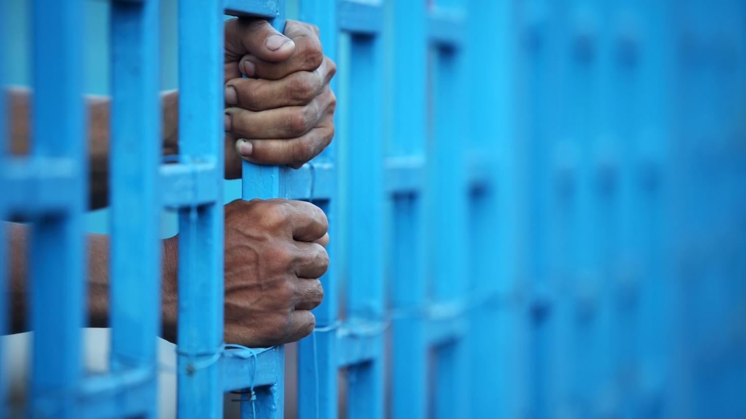 mains sur des barreaux d'un prison