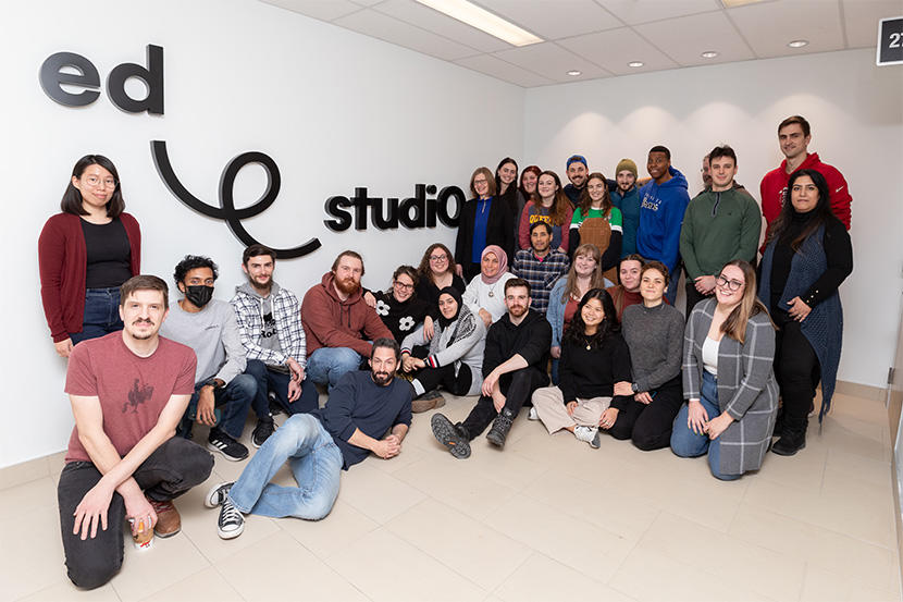 Des membres de la population étudiante posant devant le logo edstudiO.