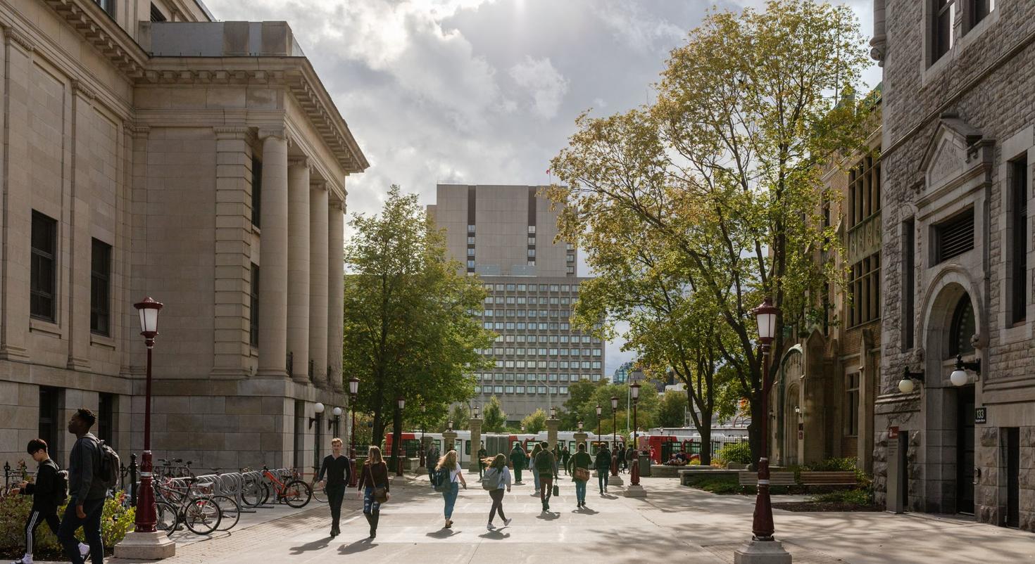 Vue du campus au début de l'automne avec des personnes marchant entre les pavillons Tabaret et Hagen.