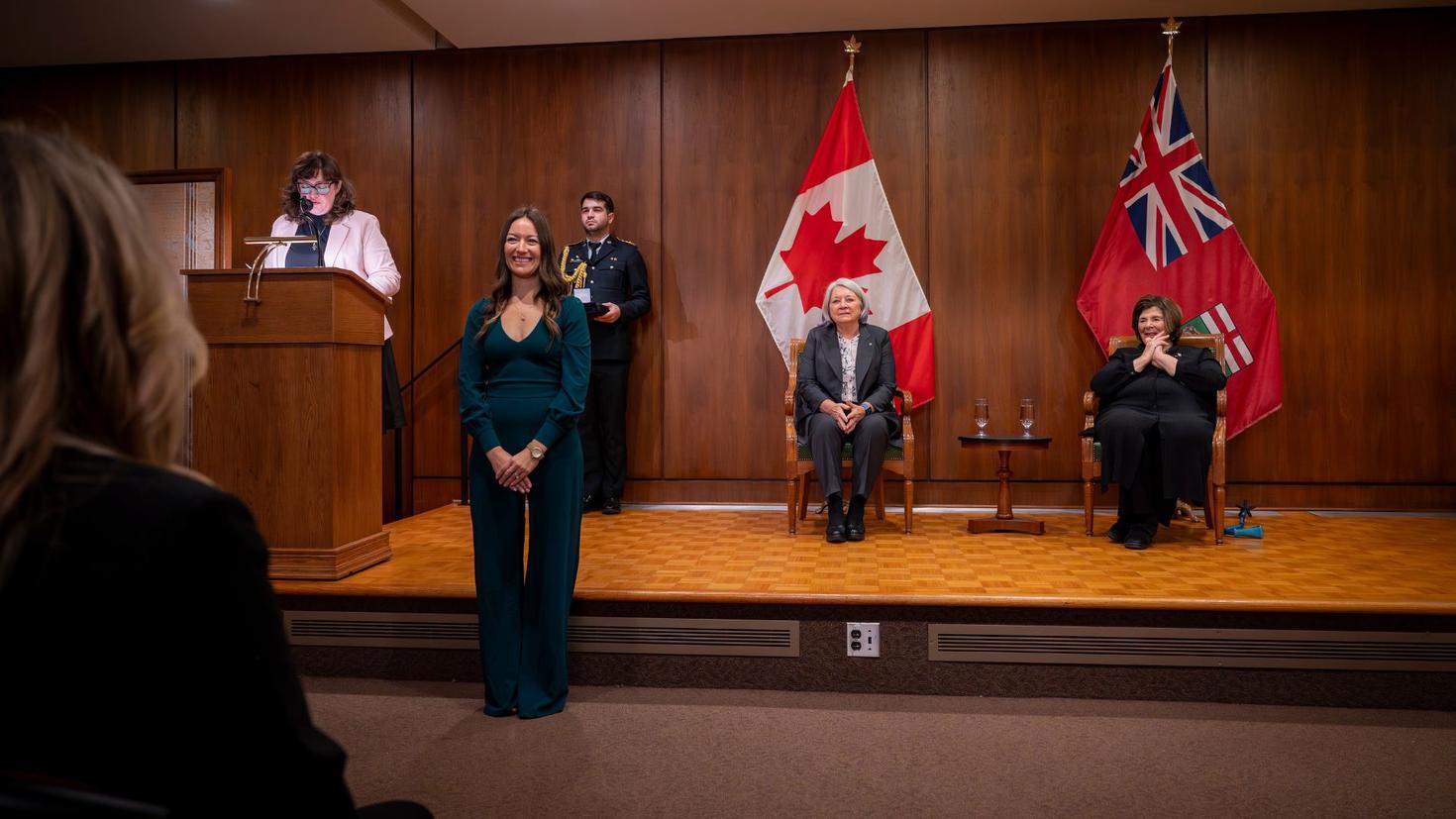 Jessica McIntyre standing in front of stage with the Governor General of Canada.