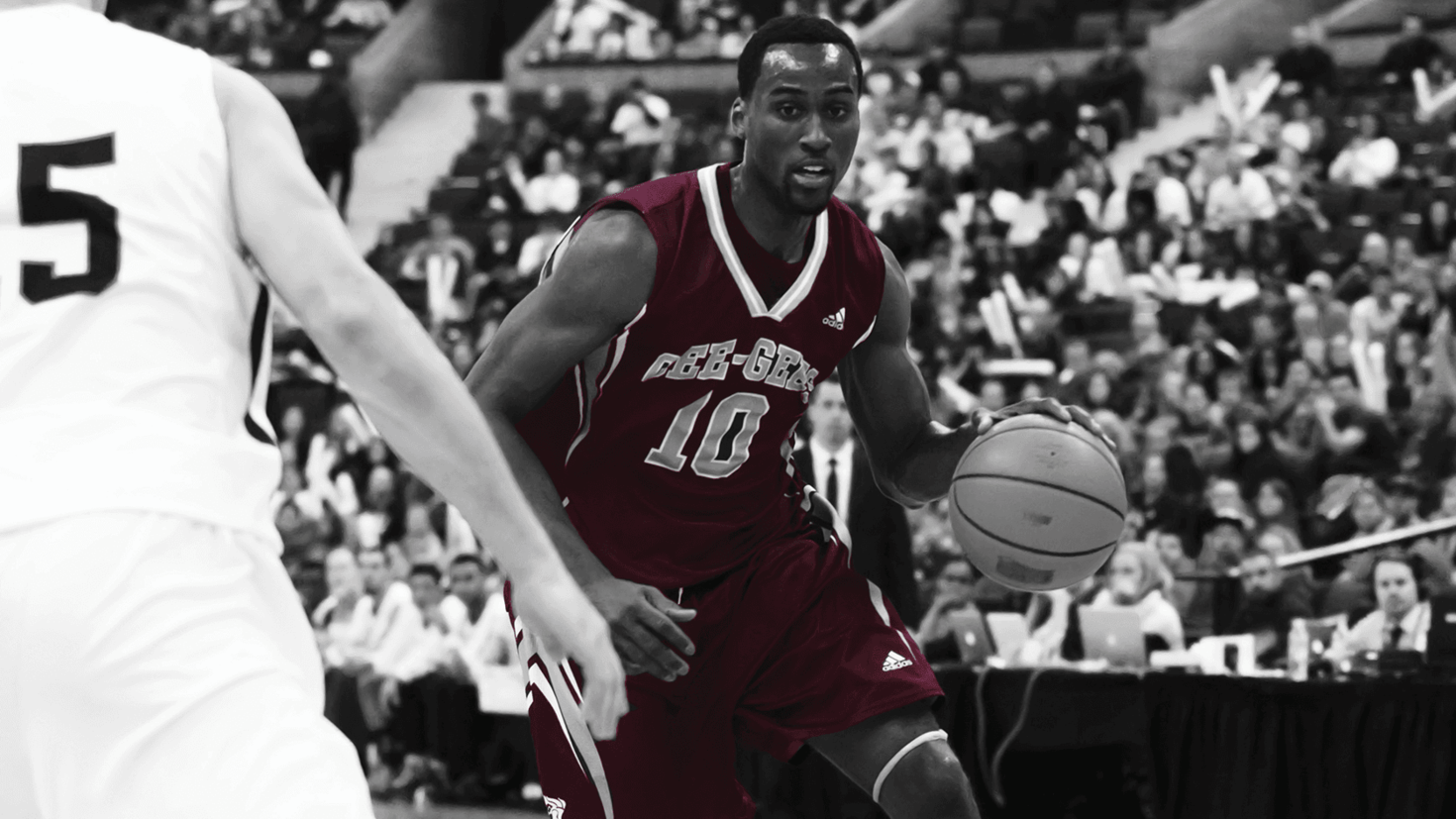 Un joueur de l’équipe de basketball des Gee-Gees essaie de dépasser un autre joueur en dribblant le ballon.