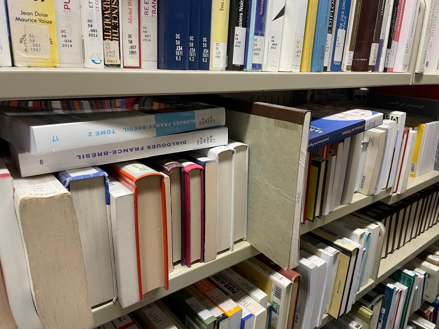 A library shelf overfilled with books