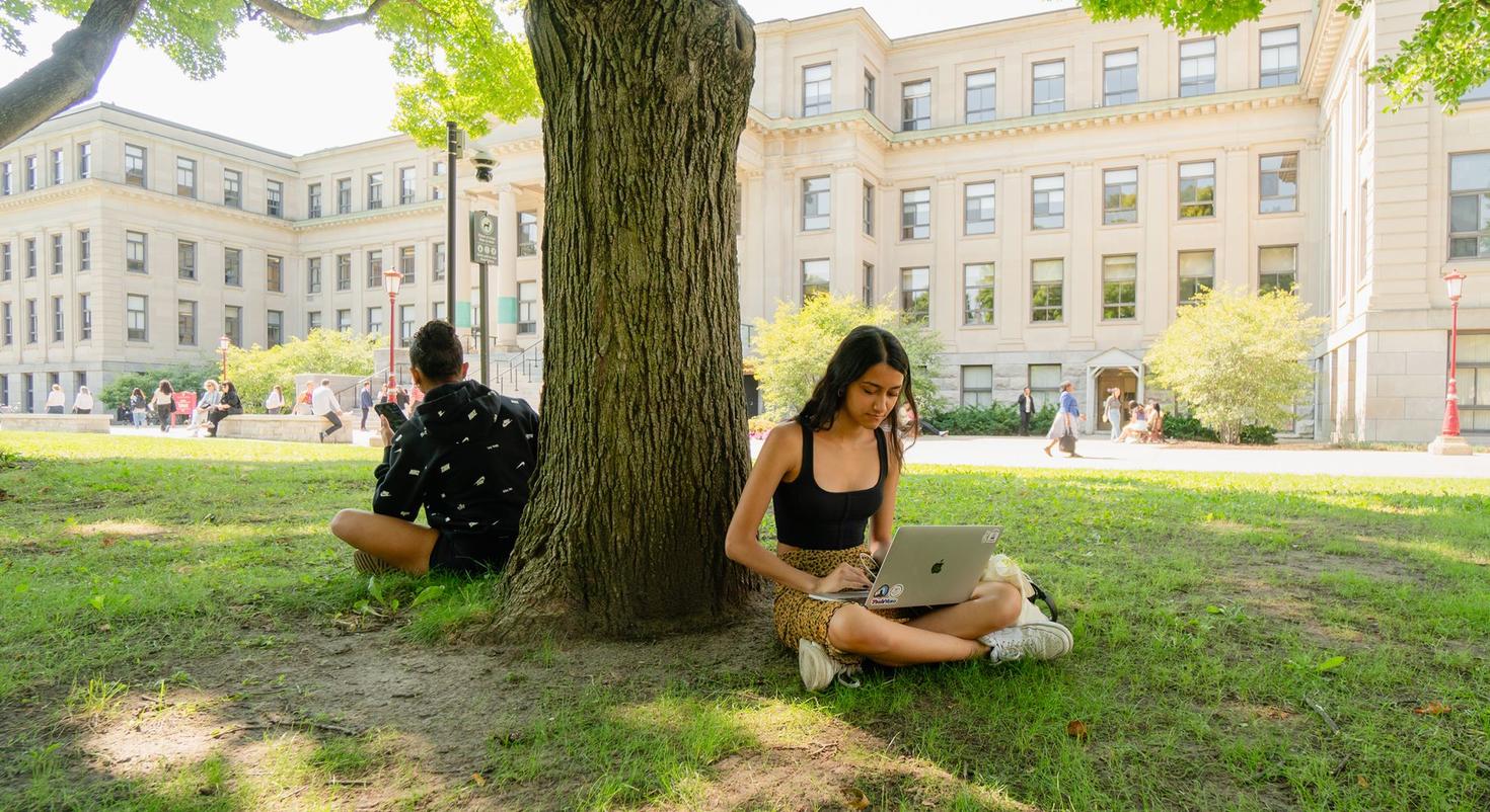 Deux étudiantes assis sous un arbre sur la pelouse Tabaret.