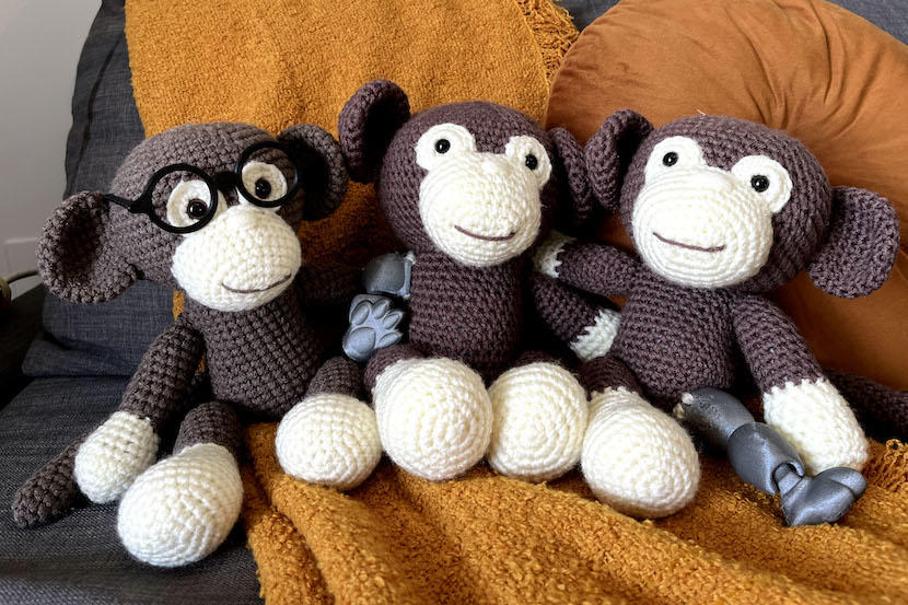 Un singe au crochet avec des lunettes, un avec un bras prothétique et un autre avec une jambe prothétique.
