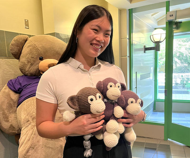 Une étudiante en médecine tenant trois singes au crochet.