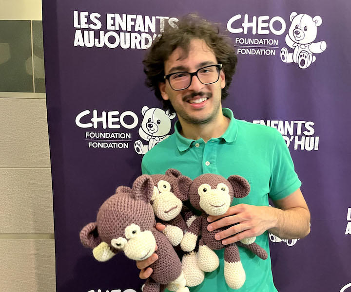 Un étudiant en médecine tenant trois singes au crochet.
