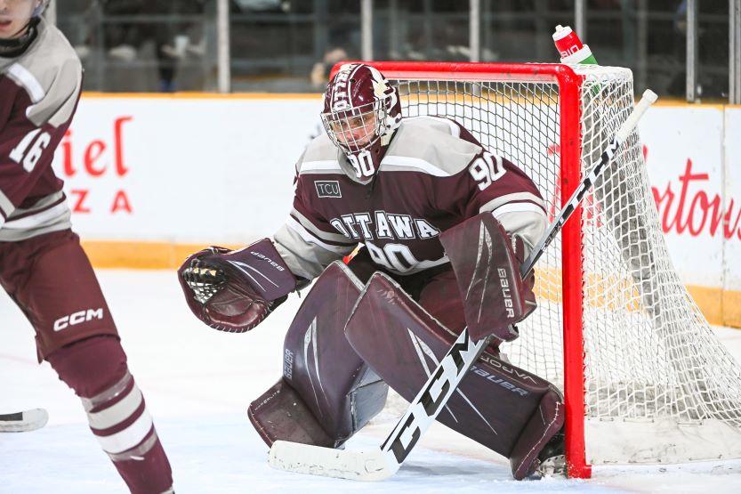 Men's Gee Gees goalie Frank Lapenna crouches in front of the net, ready for a shot.