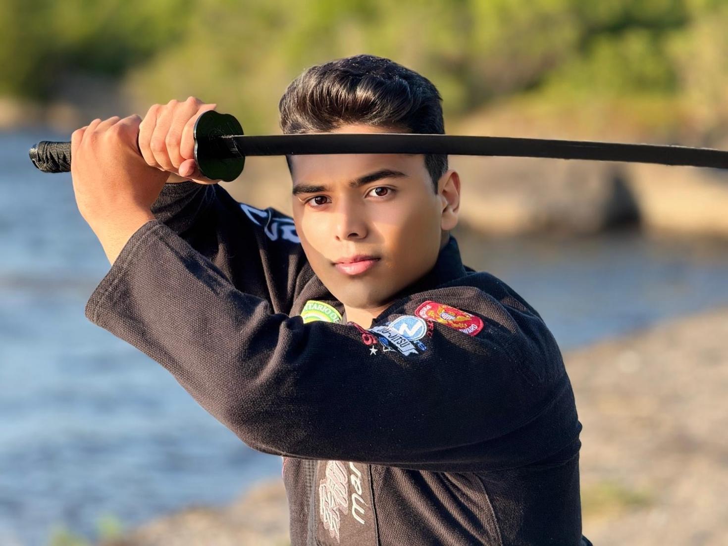 Moiz Lakhani posant, un katana à la main.