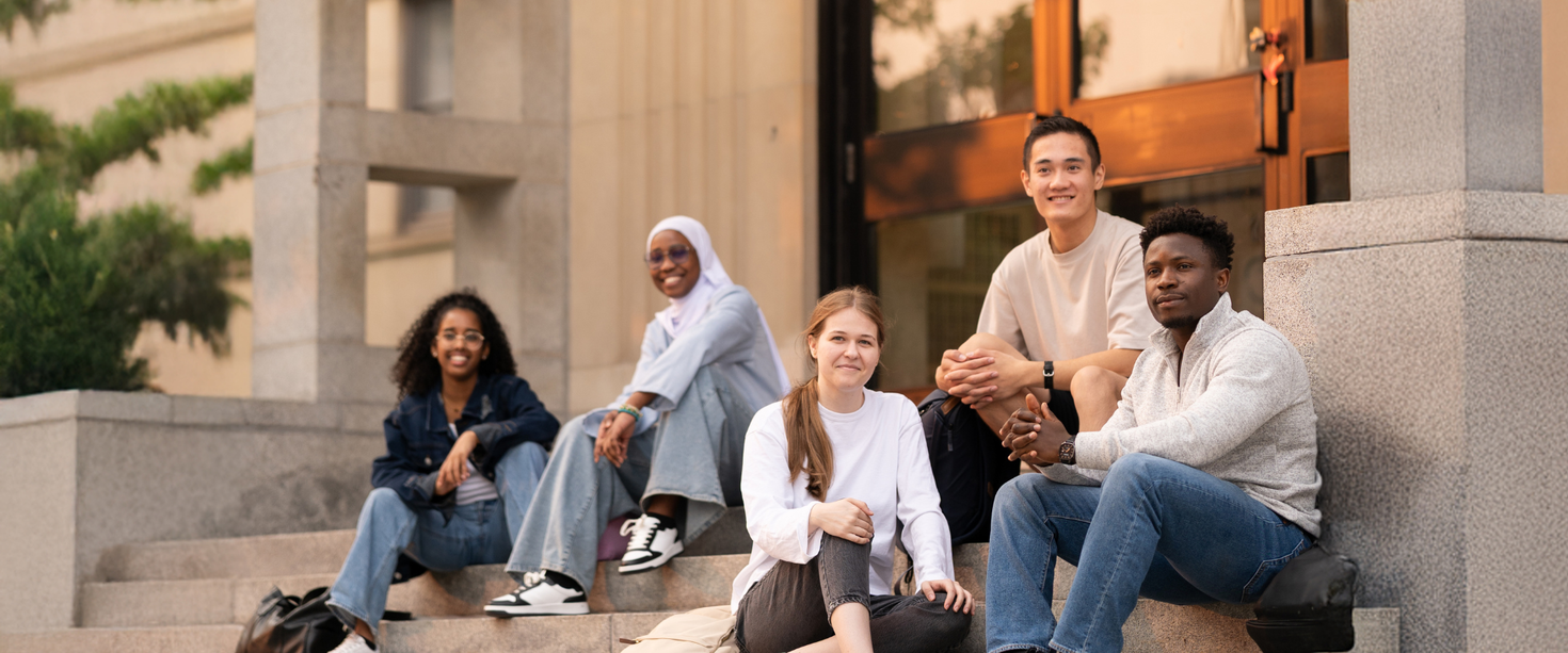 Des étudiants assis dans les escaliers devant le bâtiment Simard