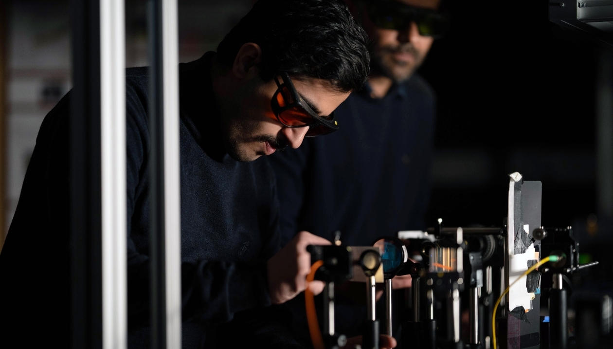 Two people studying lasers.