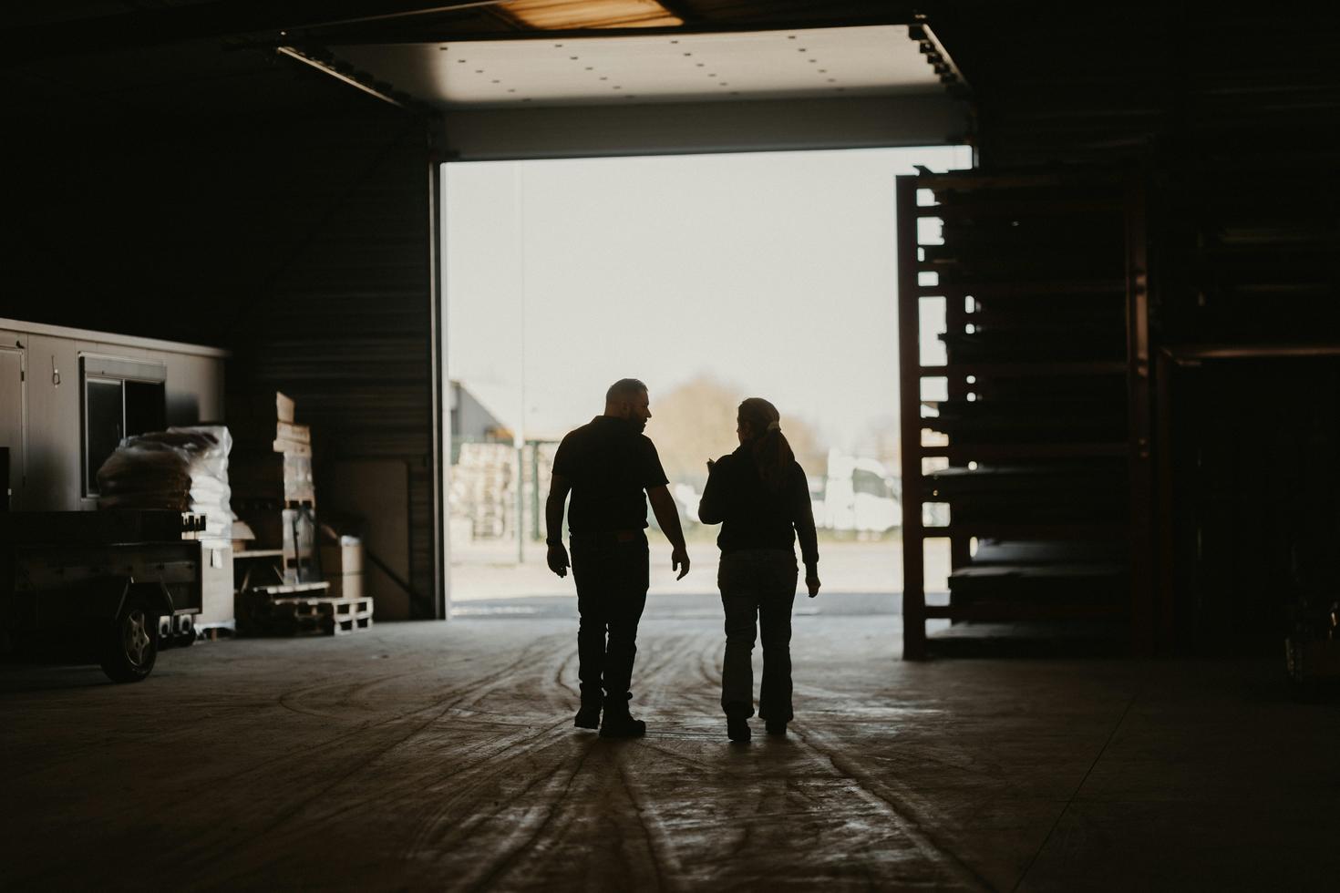 A man and a woman walking together in an industrial garage