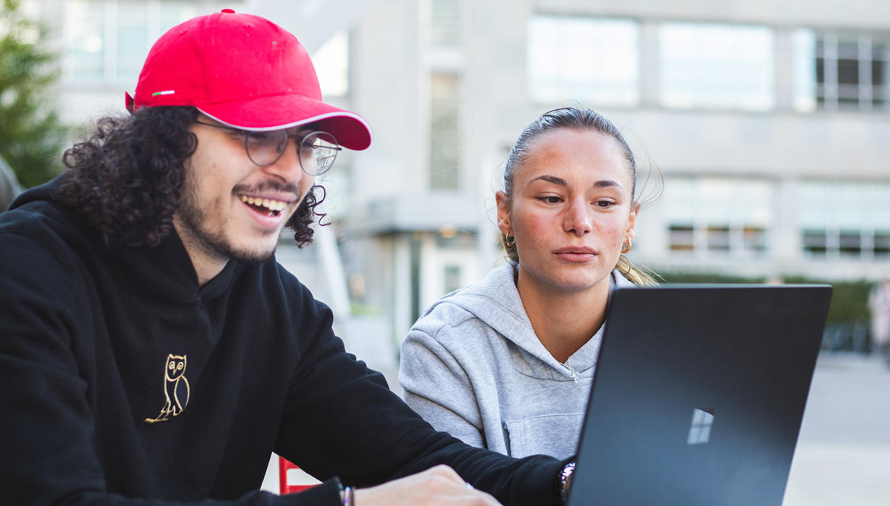 Two students looking at a laptop