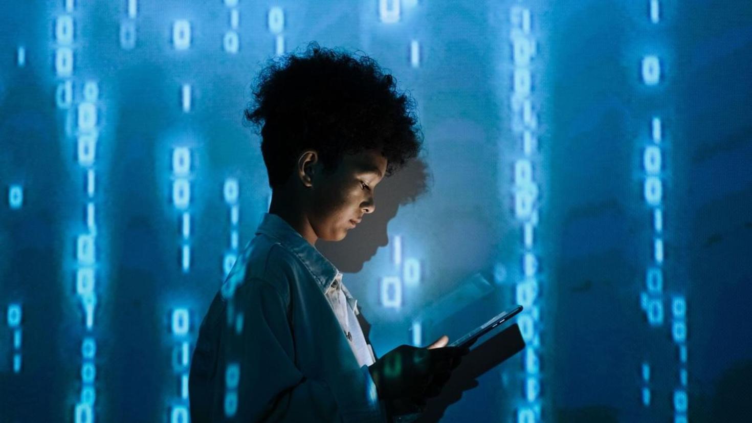 Image of a boy holding a tablet with a blue graphic background