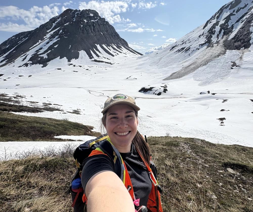 Laurence Hamel posing all smile in front of snowy mountains. 