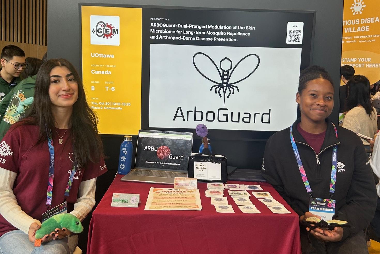 Two members of the iGEM team at their booth talking about ArboGuard.