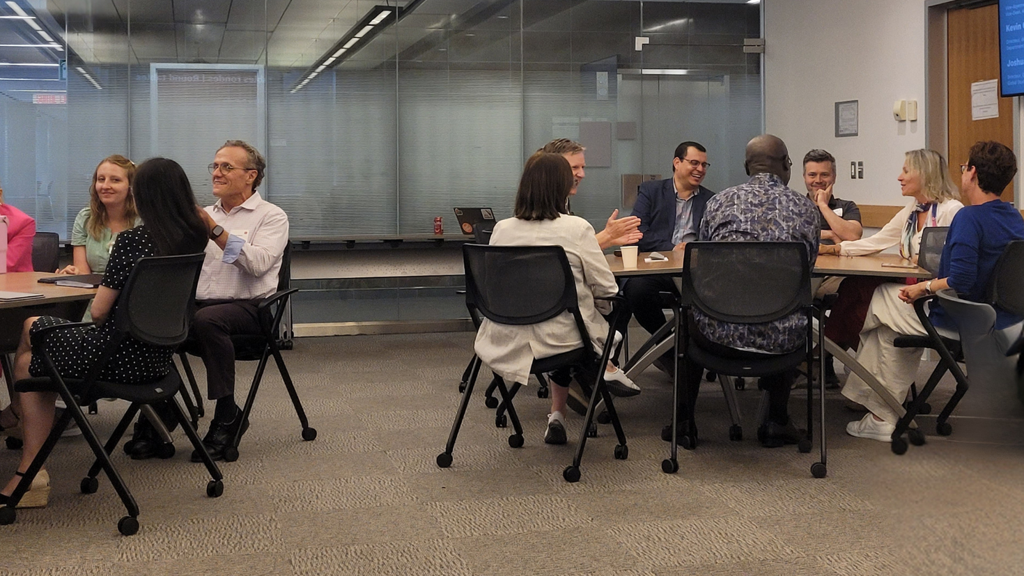 Group of professors in a uOttawa conference room, cheerfully discussing in groups