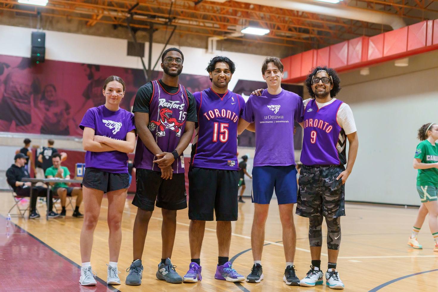 Cinq étudiantes et étudiants faisant partie d'une équipe de basket-ball intra-muros au gymnase Montpetit.